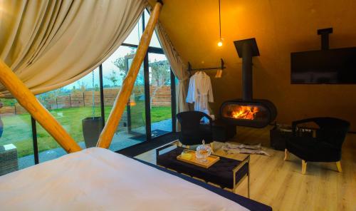 a bedroom with a bed and a fireplace in a room at 3 Hills Boutique - The Ranch Experience in Trílofos