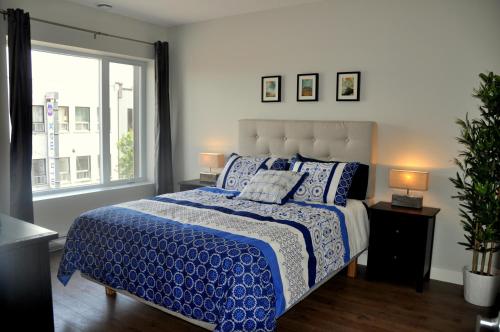 Un dormitorio con una cama azul y blanca y una ventana en Le Mont-Royal Sky by HomeInMontreal, en Montreal