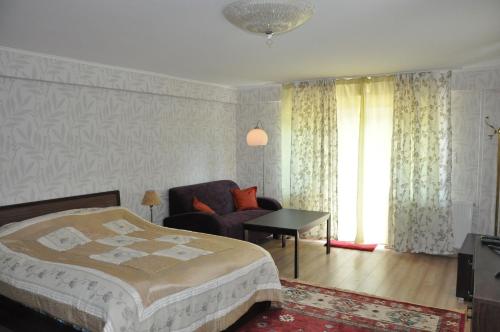 een slaapkamer met een bed, een stoel en een raam bij Villa Maria in Hévíz