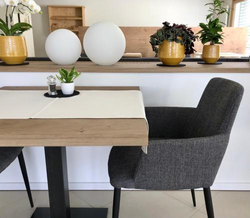 a table and chairs with plants on a shelf at Hotel Quellenhof in Naturno