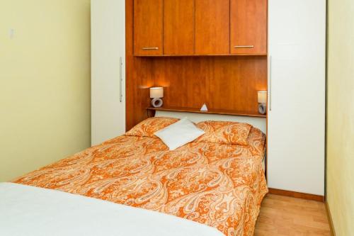 a bed in a room with a wooden cabinet at Apartment Angie - terrace with sea view in Nečujam