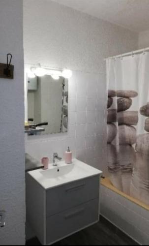 une salle de bain blanche avec un lavabo et un miroir dans l'établissement Appartement Centre Station Risoul 1850 pied des pistes LE VILLARET 2, à Risoul