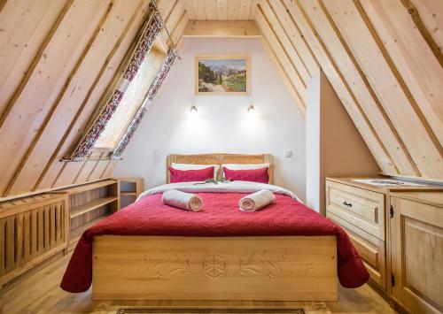 a bedroom with a red bed in a attic at ApartHost Tatra Panorama in Zakopane