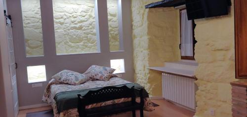 a bedroom with a bed in a room with windows at Hotel La Casa Chacinera in Candelario