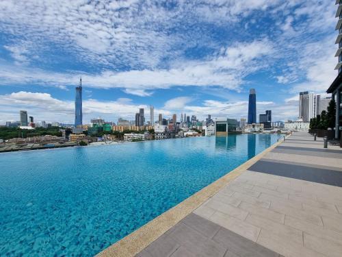 a large swimming pool with a view of a city at KL One Residence by Nest Home [Infinity Pool & KL Skyline] in Kuala Lumpur