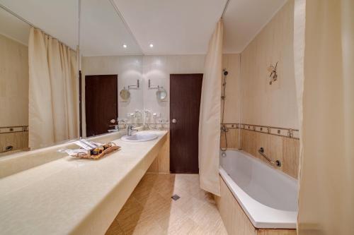 バンスコにあるHotel Bansko SPA & Holidays - Free Parkingのバスルーム(バスタブ、シンク、バスタブ付)が備わります。
