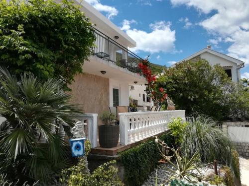 a house with a white fence and plants at Apartments Obradovic in Krasici