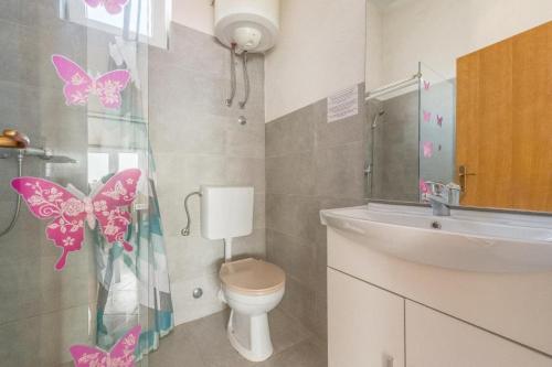 a bathroom with a toilet and butterflies on the shower curtain at Ferienwohnung in Okrug Gornji mit Meerblick, Terrasse, Klimaanlage, W-LAN 5046-3 in Novi Zagreb