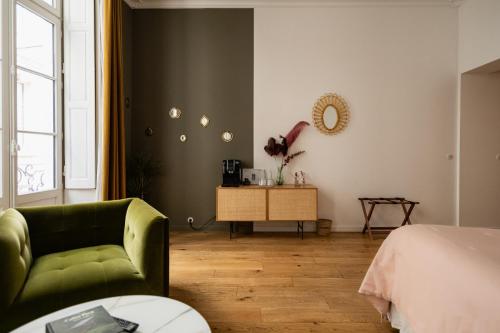 a living room with a green couch and a bed at Maison Fernand B&B in Bordeaux