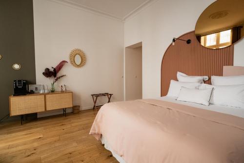 a bedroom with a large white bed and a mirror at Maison Fernand B&B in Bordeaux