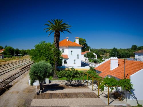 a house with a palm tree next to a train track at Train Spot Guesthouse in Marvão