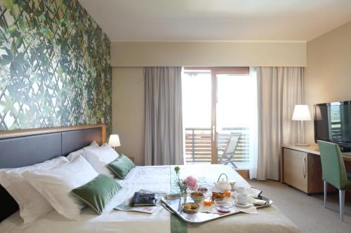una camera d'albergo con un letto e un vassoio di cibo sopra di Relais Le Betulle a Conegliano