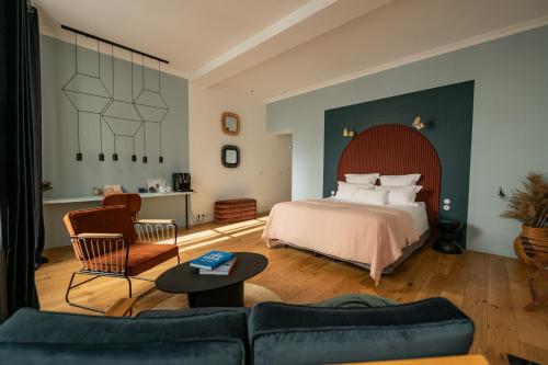 a hotel room with a bed and a couch at Maison Fernand B&B in Bordeaux
