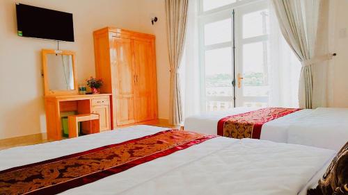 a hotel room with two beds and a window at Villa Trung Nghĩa 30 in Da Lat