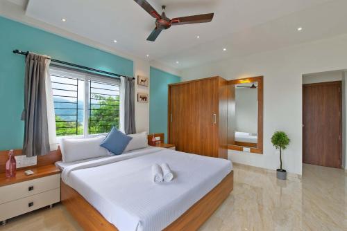 a bedroom with a large white bed and a window at SaffronStays Riverdale, Mulshi - Lakefront villa with pool and mountain view in Pune