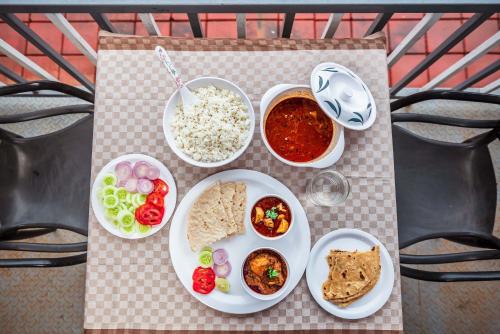 a table with plates of food on a table at SaffronStays Riverdale, Mulshi - Lakefront villa with pool and mountain view in Pune