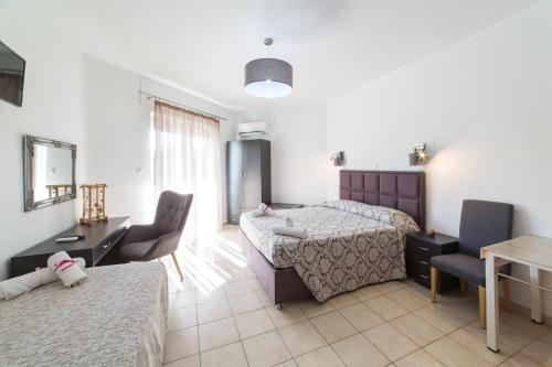 a bedroom with two beds and a table and chairs at Anelia Boutique Studios & Apartments in Faliraki