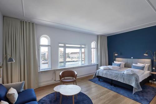 een slaapkamer met een bed en een blauwe muur bij Copenhagen Strand in Kopenhagen