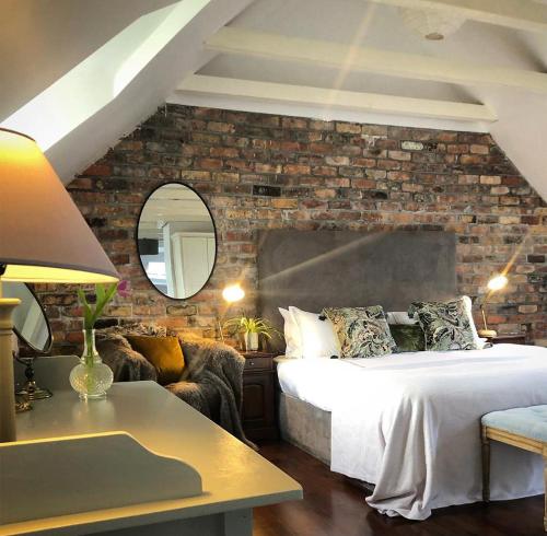 a bedroom with a bed and a brick wall at Courtyard Cottages in Tralee