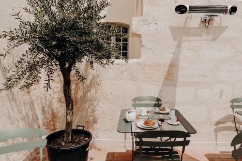 a table and chairs with a tree in a room at Maison Fernand B&B in Bordeaux