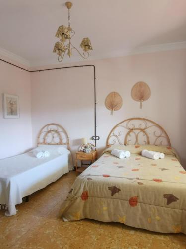 a bedroom with two beds and a chandelier at Les violetes in Serra de Almós