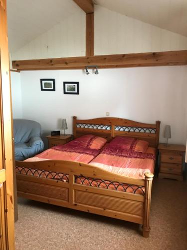 ein Schlafzimmer mit einem großen Holzbett in einem Zimmer in der Unterkunft Weingut-Ferienhof Schäfer in Göcklingen