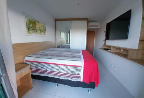 una piccola camera con letto e TV a schermo piatto di Excelente flat térreo condomínio villa monte castelo a Bezerros