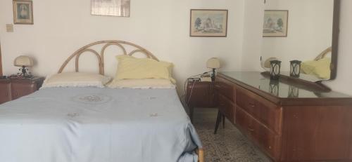 1 dormitorio con cama, tocador y espejo en Attico in centro con vista mare e monti!, en Marina