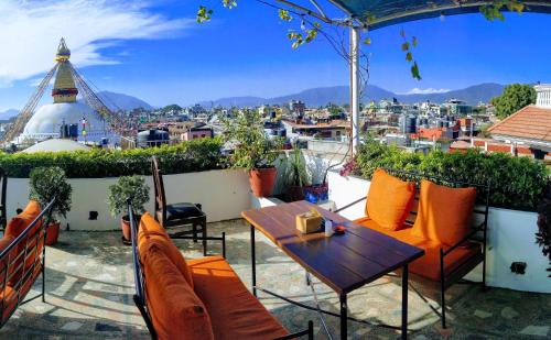 a patio with a table and chairs and a view of a city at Hotel Bodhiz in Kathmandu