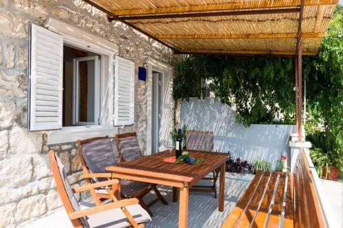 Une table et des chaises en bois sont disponibles sur la terrasse. dans l'établissement Holiday Home Anima Maris, à Ston