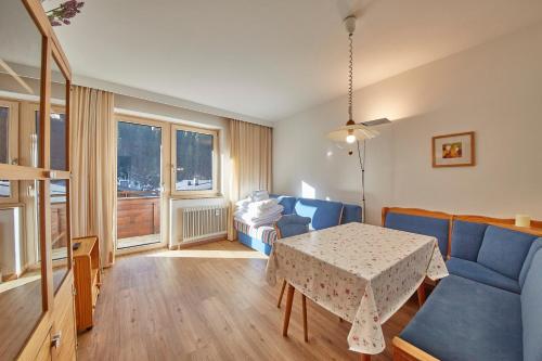 salon ze stołem i niebieską kanapą w obiekcie Appartement Delight w Saalbach Hinterglemm