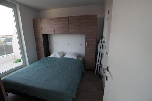 a bedroom with a bed and a large window at White Princess-Yzzis in Koksijde