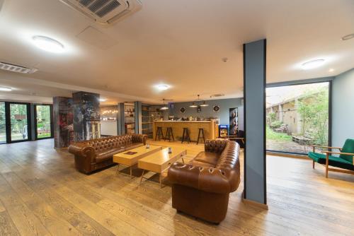 a living room with leather furniture and a table at Urban Park Hotels in Tbilisi City