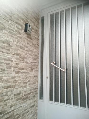 a white door with a metal rail next to a brick wall at "ΑΡΜΟΝΊΑ" ΔΙΑΜΕΡΙΣΜΑ, ΚΑΛΑΜΑΤΑ-"HARMONY" apartment, Kalamata in Kalamata