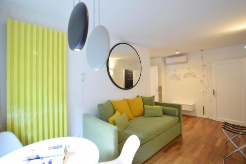 a living room with a green couch and a mirror at Isola Memmia in Padova