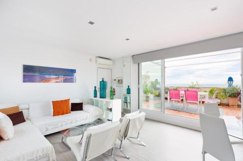 sala de estar con muebles blancos y ventana grande en Stay U-nique Apartments Taulat, en Barcelona