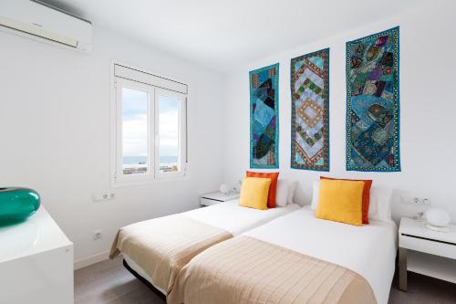 a white bedroom with two beds and a window at Stay U-nique Apartments Taulat in Barcelona