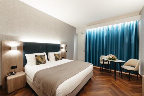 a hotel room with a large bed and a table at Hotel Motel Prestige in Grugliasco