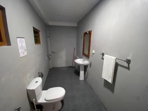 a bathroom with a toilet and a sink at Una Beach Hotel & OLU Cafe in Unawatuna