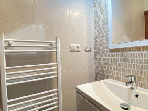 La salle de bains blanche est pourvue d'un lavabo et d'un miroir. dans l'établissement Los Naranjos 18B Casasol Capistrano Village, à Nerja
