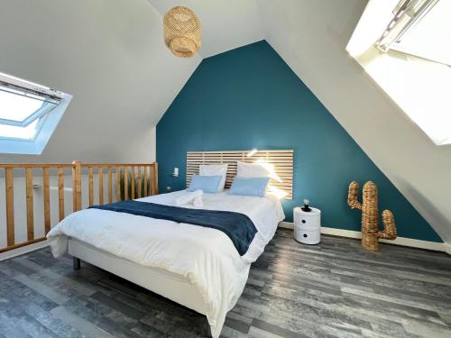 sypialnia z dużym łóżkiem z niebieską ścianą w obiekcie Cosy Casa w mieście Abbeville