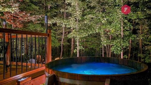 a large wooden tub on a deck with trees at The Marco-Polo of Portneuf - Open on nature - Private SPA Pool Sauna in Pont-Rouge