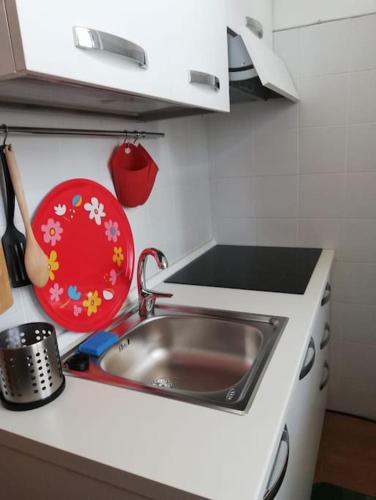 a kitchen with a sink and a red plate at La Quercia Fiorita in Trivolzio
