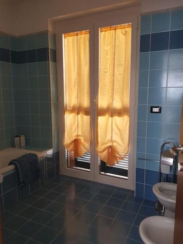 a bathroom with a window and a sink and a tub at La Quercia Fiorita in Trivolzio