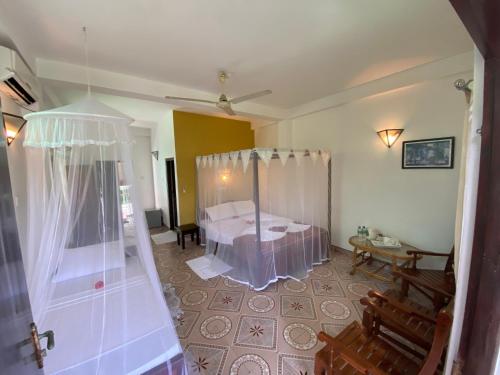 a bedroom with a bed and a tub in it at Una Beach Hotel & OLU Cafe in Unawatuna