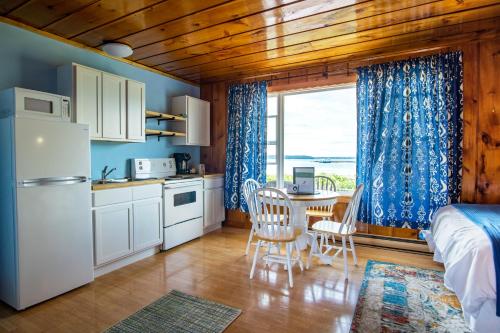 a kitchen and dining room with a bed and a table at Friars Bay Inn & Cottages in Welshpool