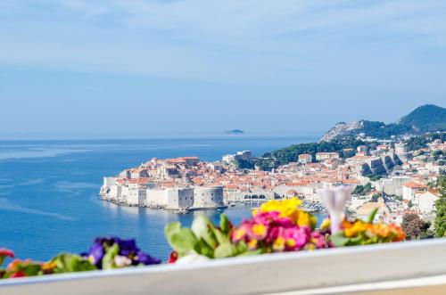 a view of a city with flowers on a ledge at Apartment Vedrana in Dubrovnik