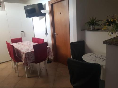 a dining room with a table and red chairs at La Quercia Fiorita in Trivolzio