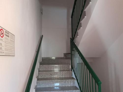 a set of stairs with green railings in a building at La Quercia Fiorita in Trivolzio