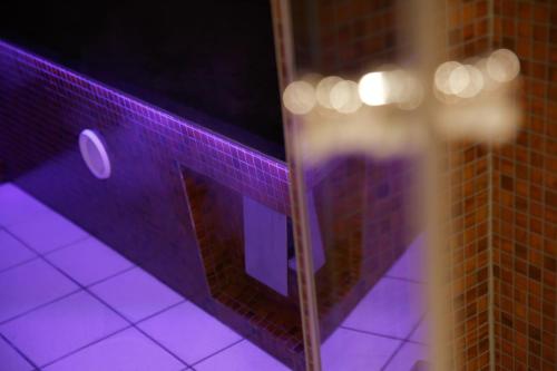 a purple tiled wall with a mirror in a bathroom at Hotel TURNA Malbun in Malbun